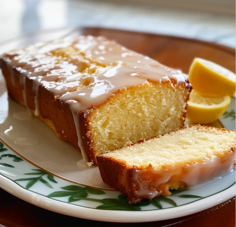 Slice of old-fashioned lemon pound cake on a plate with fresh lemons
